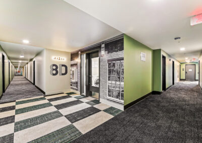 Interior hallway at 900 Rainier with patterned flooring and room number signs.