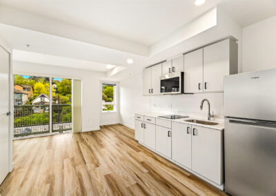 Bright open-plan apartment at 900 Rainier with white kitchen cabinetry and wood floors.