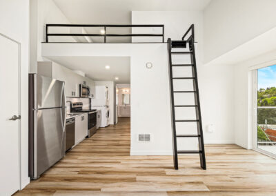 Lofted apartment at 900 Rainier showcasing sleeping loft, ladder, and natural light.